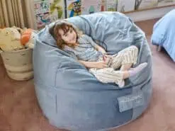 Child sitting comfortably on a foam filled Kids bean bag in her room.