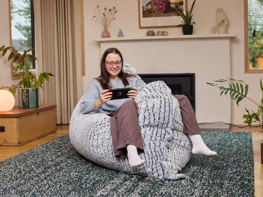 A teenager relaxing on a Stone Fur 3-in-1 foam filled bean bag while gaming at home.
