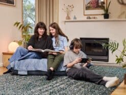 A mother with a teenage girl and a boy enjoying time on a Persian Blue velvet foam filled 3-in-1 bean bag in a bright, comfortable living room set.