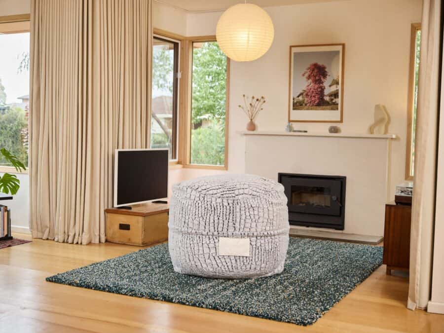 Modern foam filled Kids Stone Fur bean bag in a peaceful living room with large windows and warm decor.