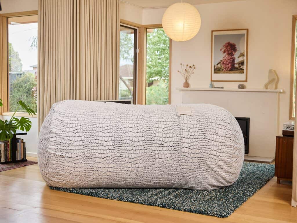 Large Stone Faux Fur foam filled Lounge bean bag in a calm living room with natural light.